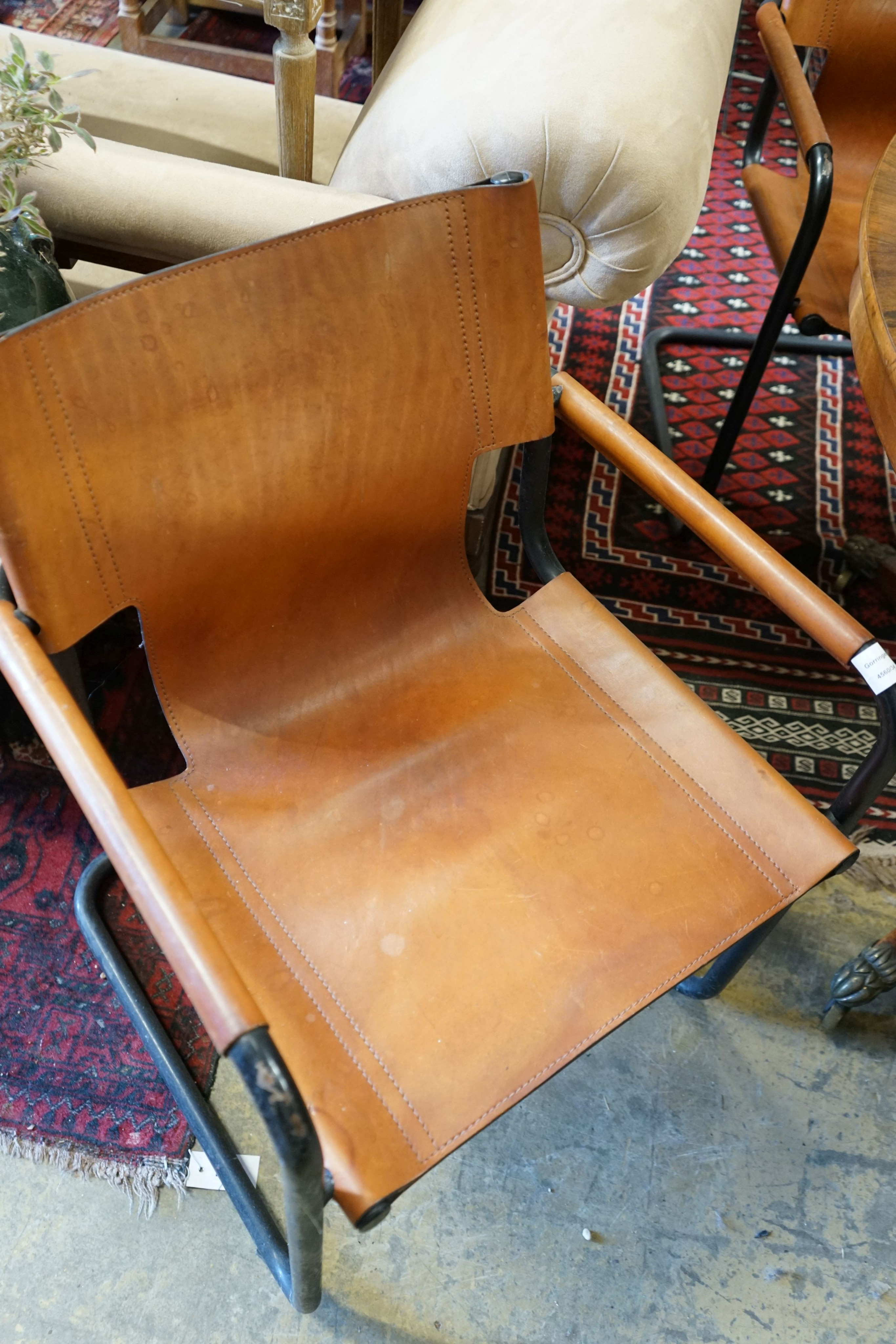 A set of four contemporary tan leather cantilver dining chairs, width 56cm depth 50cm height 79cm